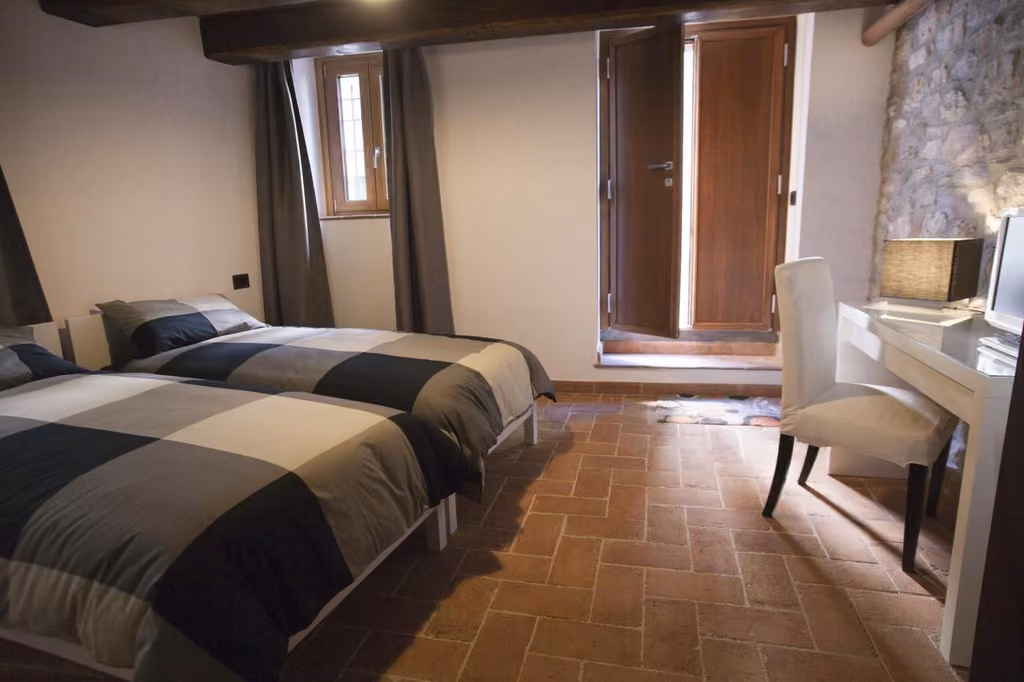 Camera doppia del B&B Largo Alighieri a Schiavi di Abruzzo, con due letti, scrivania e finestra sul borgo